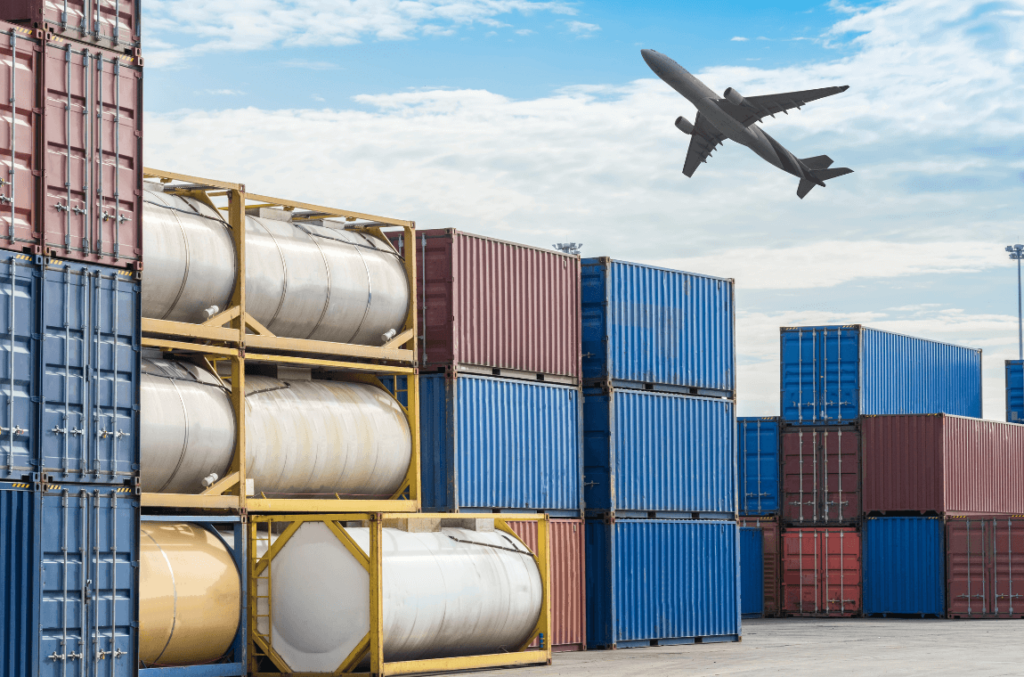 Airplane flying over fuel containers at a loading dock