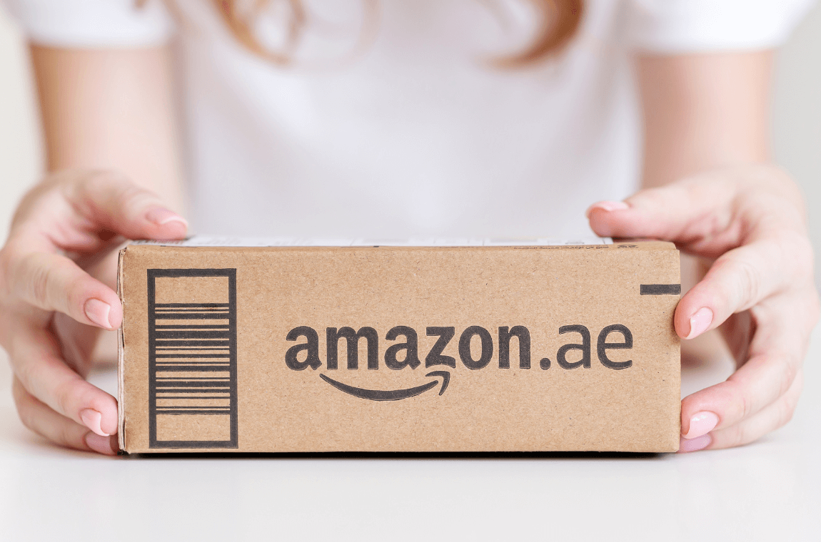 Businesswoman holding Amazon-branded box, representing success in Fulfillment by Amazon (FBA) program